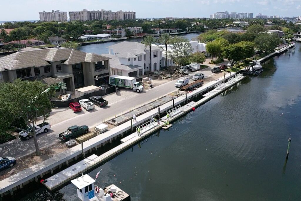 A modern barge with a sleek design docked at a waterfront, showcasing the 230 N. Compass Barge2.