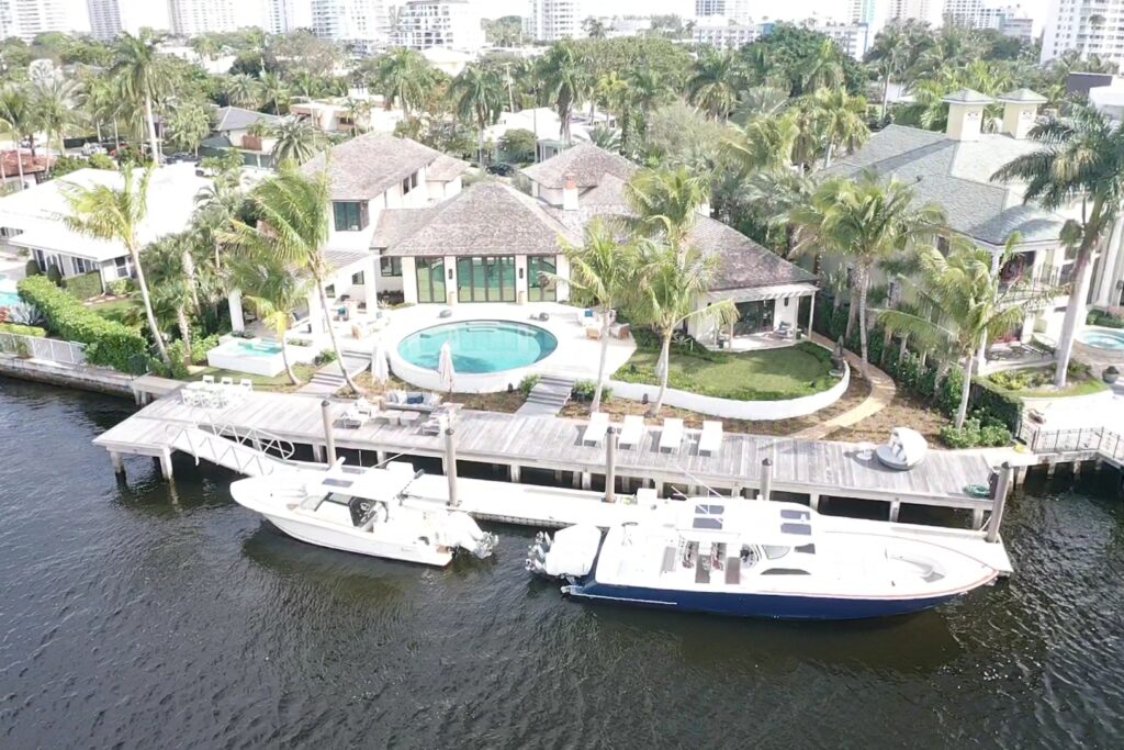 A modern home with a spacious deck overlooking a river, showcasing serene outdoor living at 509 Middle River 4.