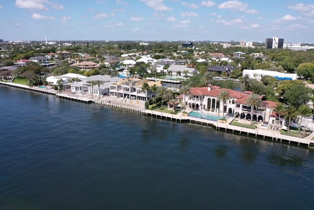 Modern coastal home exterior with large windows, showcasing the design of the Compass Intercoastal Side 3.