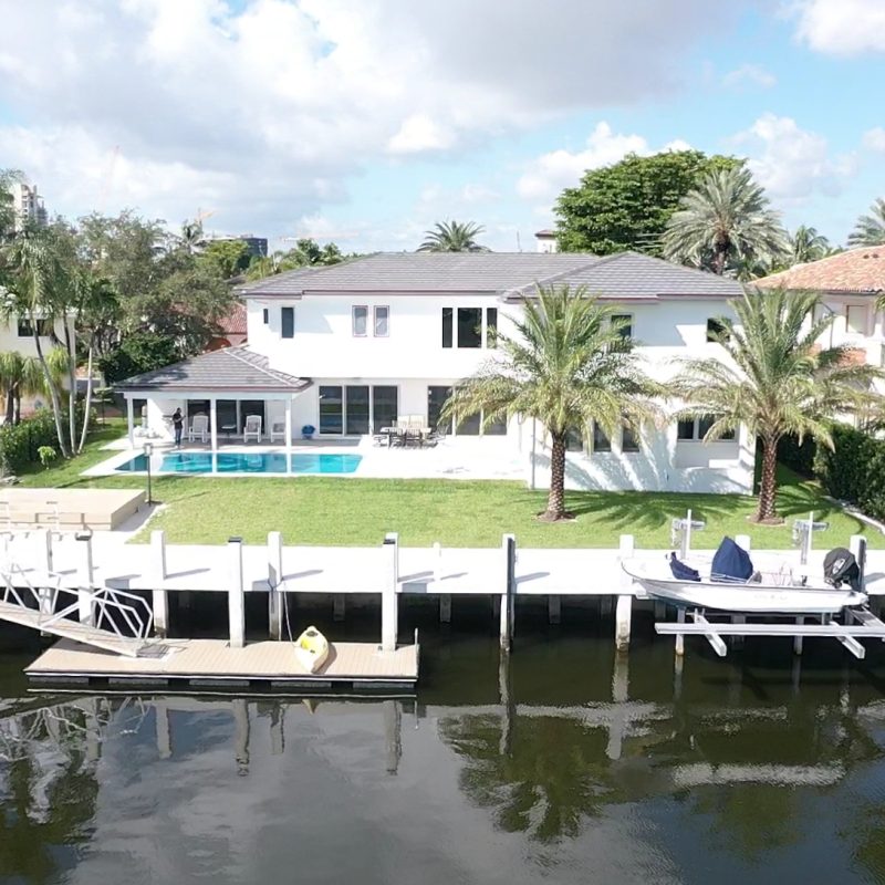 Exterior view of 33 Isla Bahia Dr. 2, showcasing modern architecture and landscaping in a sunny setting.