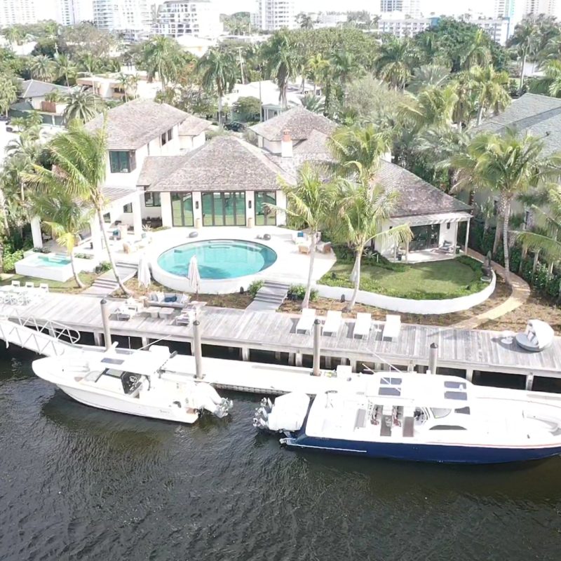 A modern home with a spacious deck overlooking a river, showcasing serene outdoor living at 509 Middle River 4.