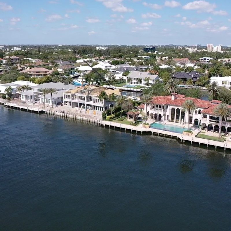 Modern coastal home exterior with large windows, showcasing the design of the Compass Intercoastal Side 3.